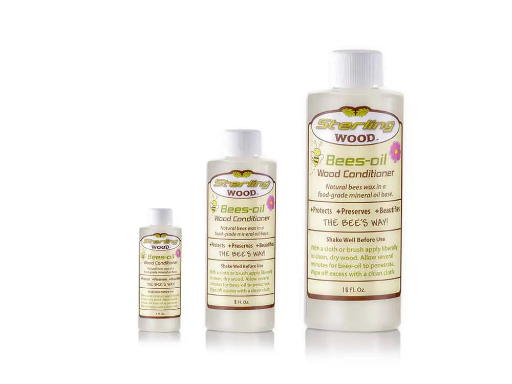 Three bottles of Sterling Wood Bees-oil Wood Conditioner in different sizes, labeled with product details and benefits