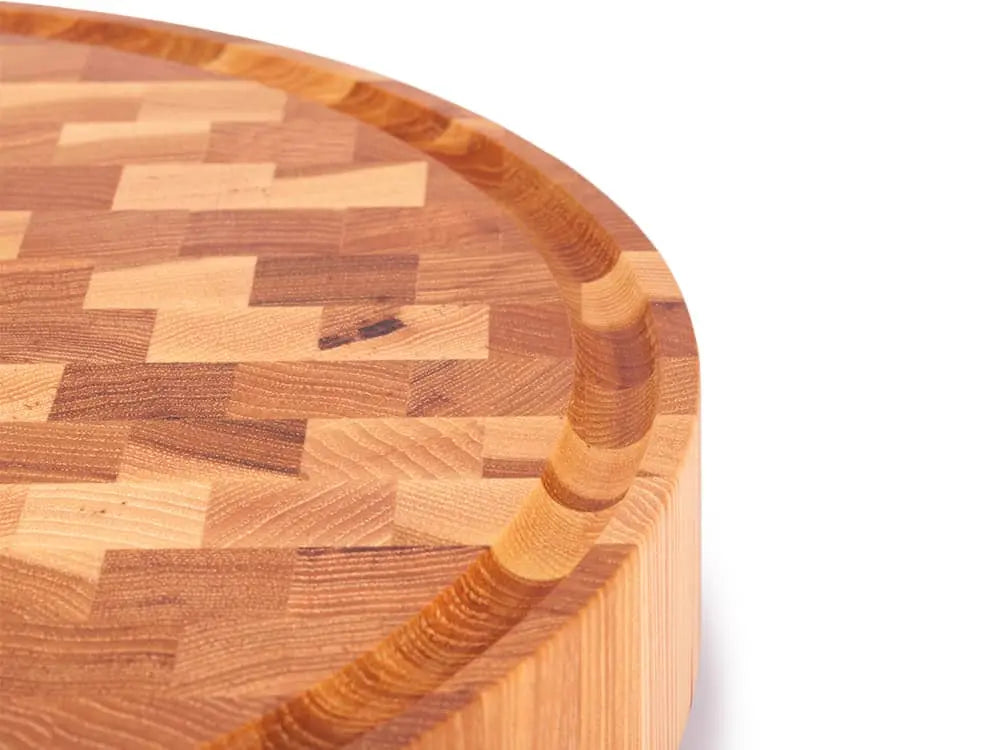 Close-up of a round hickory end grain butcher block with a juice groove