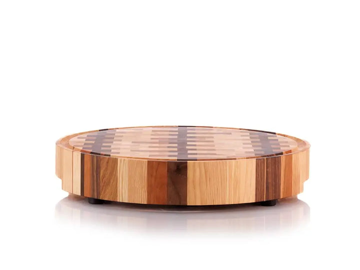 Round end grain butcher block with a checkered pattern, shown from a low angle, on a white background
