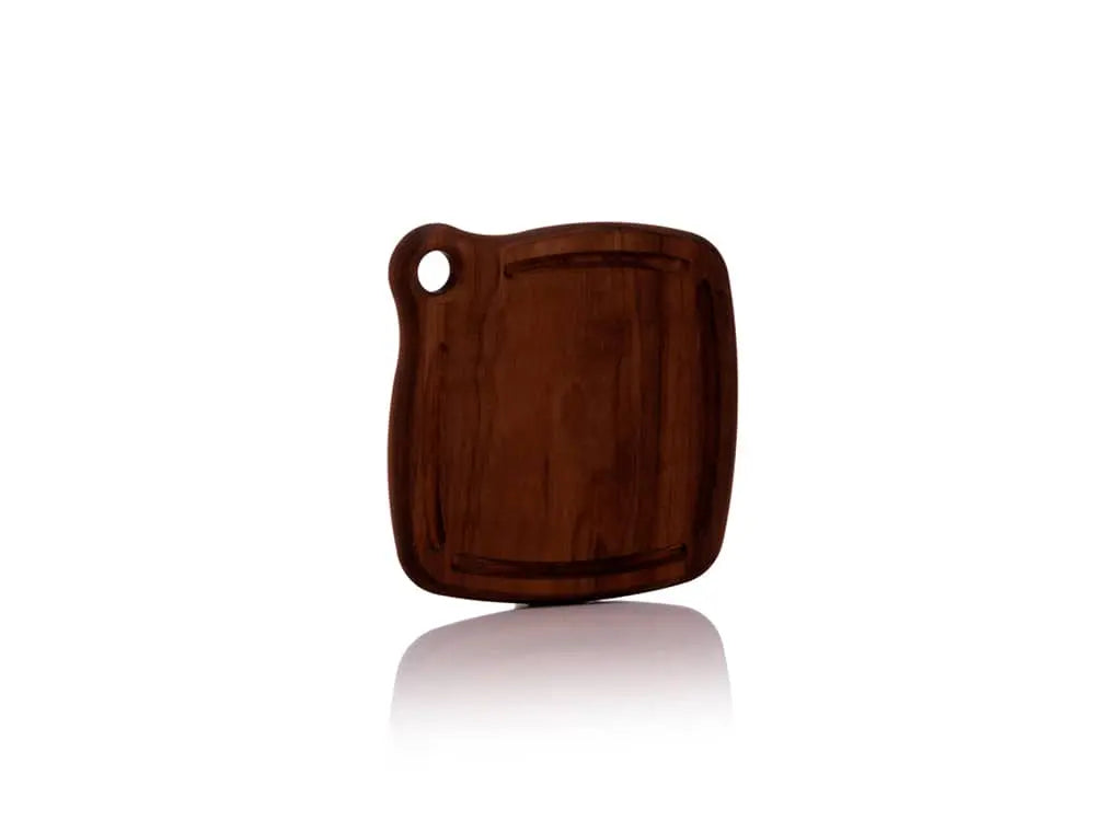 Front view of the Iron Wood Trivet standing upright, crafted from a single piece of dark walnut wood, featuring a grommet hole for hanging and a glossy beeswax oil finish, on a white background