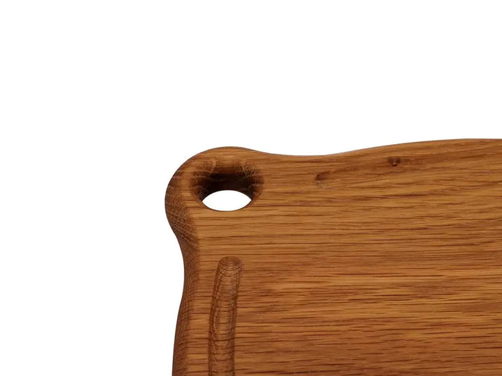 Close-up of the Iron Wood White Oak Trivet handle, showcasing the smooth finish and grommet hole