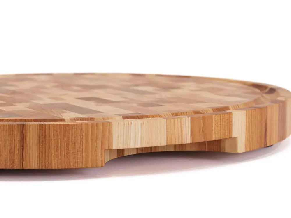Side view of a round end-grain cutting board with a checkered pattern of various wood tones, featuring a smooth finish, against a white background