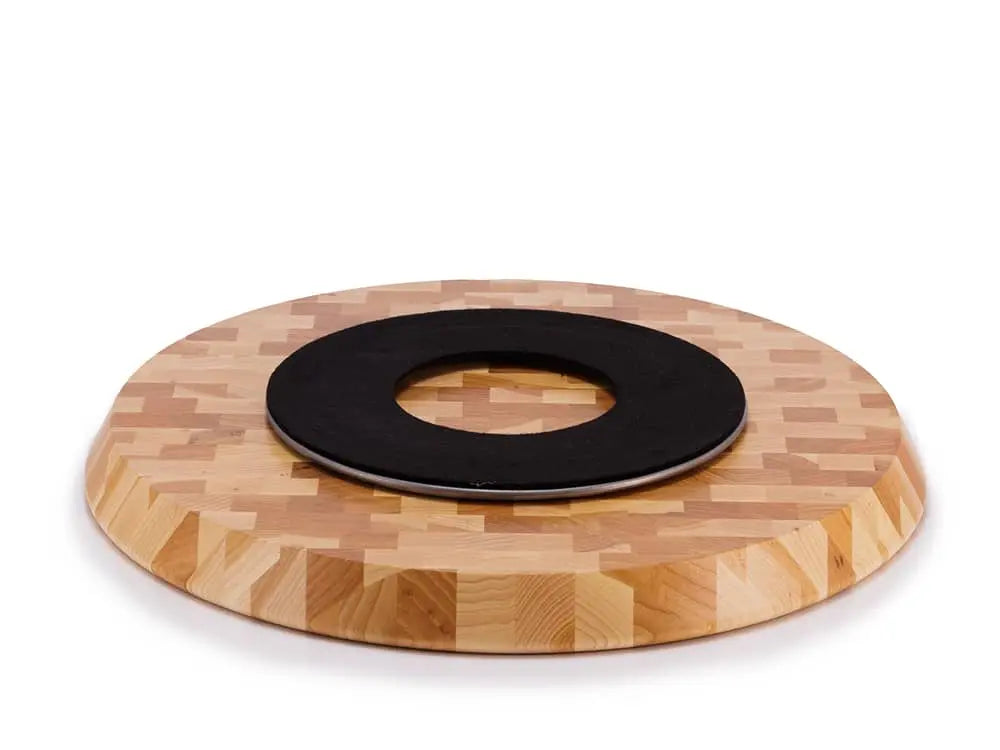 Bottom view of a round end-grain lazy susan with a light brown geometric mosaic pattern in various shades of hickory wood, showing a black protective felt pad, on a white background