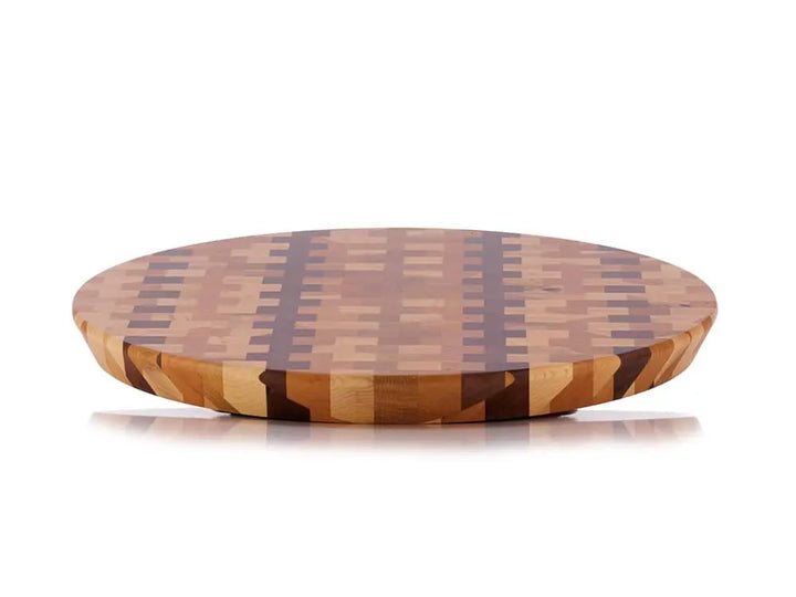 Front view of a round end-grain lazy susan with a geometric mosaic pattern featuring dark brown vertical stripes and lighter brown squares, on a white background