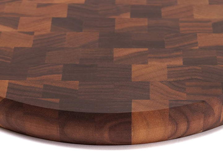 Close-up top view of a black walnut end-grain charcuterie board with a checkered pattern of various wood tones, showing the intricate grain and texture