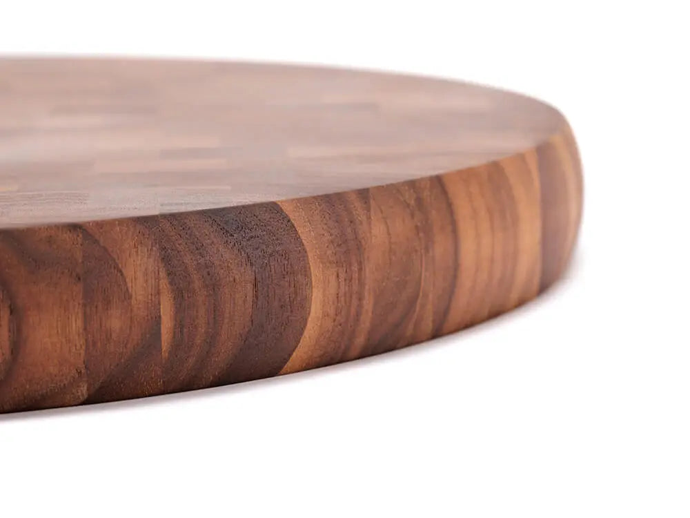 Close-up, side view of a black walnut end-grain charcuterie board board with a checkered pattern of various wood tones, featuring a smooth finish, against a white background