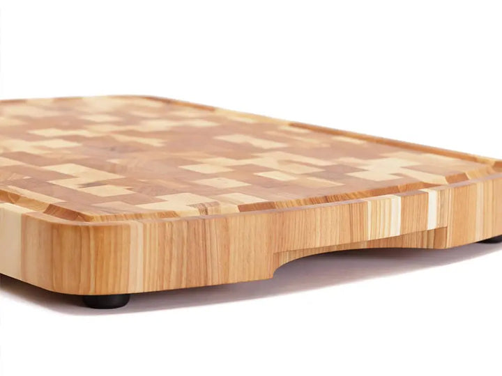 Close up, side view of a Hickory Nut end grain cutting board with a checkered pattern and rounded edges, against a white background