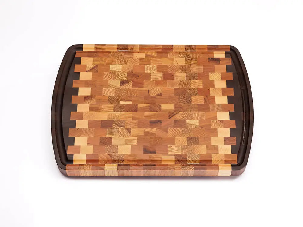 Top view of an end-grain cutting board with a checkered pattern of various wood tones, featuring rounded corners and a smooth finish, against a white background